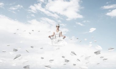 Kadın beyaz giyim gözler tutmak kapalı ve seyir kağıt uçaklar hava bulutlu gökyüzü ile arka plan üzerinde uçan arasında meditasyon sırasında konsantre.