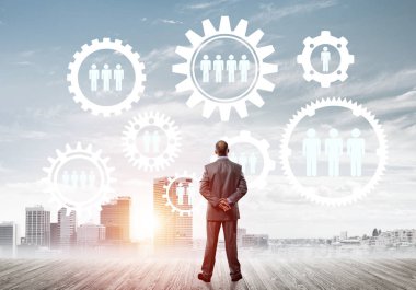 Modern şehir manzarası ve vites bağlantısı fikrine bakan işadamlarının arka planı