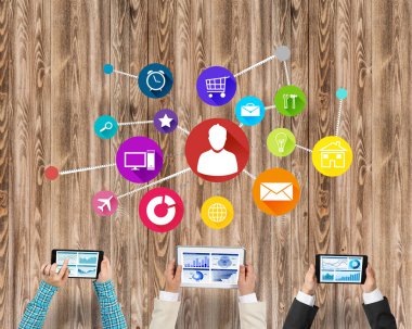 Ellerinde cihazlar bulunan üç kişilik bir grup iletişim ve ağ oluşturma sembolü olarak birlikte çalışıyor.