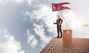 Çatıda duran ve elinde kırmızı bayrak tutan bir iş adamı. Karışık ortam