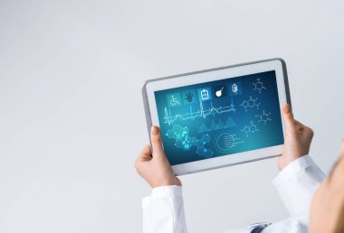 Doktorun ellerinde ilaç arayüzü ekranı olan tablet pc aygıtı