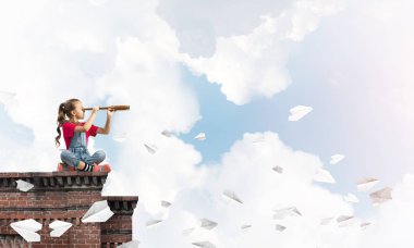 Evin çatısında oturan ve dürbüne bakan tatlı bir kız.