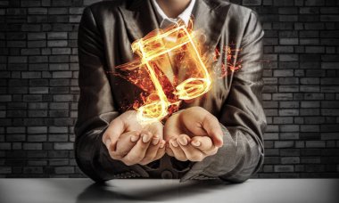 İşadamı yanan müzik sembolü arka plan üzerinde koyu duvara eliyle tutarak siyah elbiseli closeup.