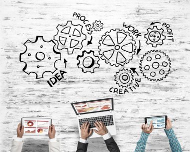 Ellerinde cihazlar bulunan üç kişilik bir grup iletişim ve ağ oluşturma sembolü olarak birlikte çalışıyor.