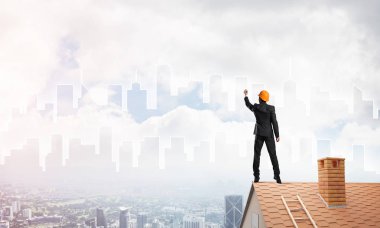 Mühendis, evinin çatısına geri döndü ve şehri çiziyor. Karışık ortam