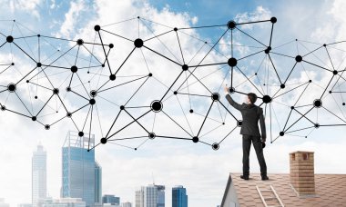 Delikanlı çatıda dikiliyor ve bağlantı hatları çiziyor. Karışık ortam