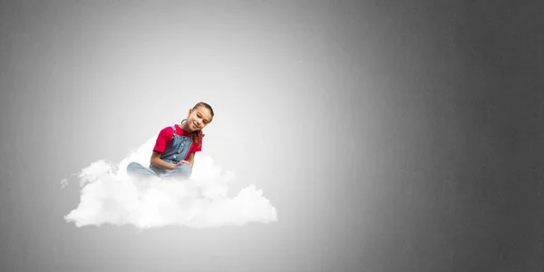 青色の背景の雲に座っているかわいい子供女の子 — ストック写真