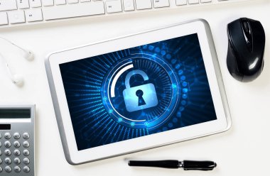 Ofis eşyalarıyla iş yeri ve ekranda asma kilit simgesi olan tablet