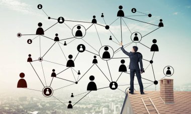 Delikanlı çatıda dikiliyor ve bağlantı hatları çiziyor. Karışık ortam