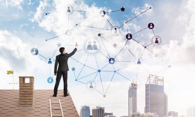 Delikanlı çatıda dikiliyor ve bağlantı hatları çiziyor. Karışık ortam