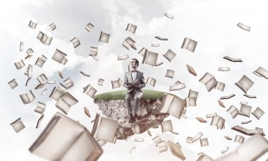 Komik adam kırmızı gözlük ve yüzen ada üzerinde oturan ve kitap okuma takım elbise