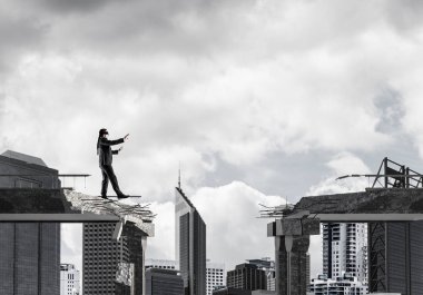 Gizli tehditlerin ve risklerin sembolü olarak beton köprüde gözü kapalı yürüyen bir iş adamı. Arka planda şehir manzarası. 3B görüntüleme.