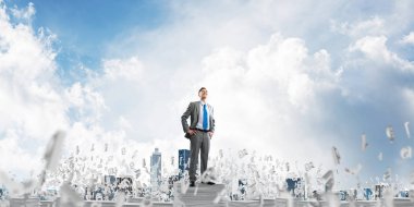 Clear sky harflerle arka plan üzerinde uçan arasında belgeleri yığını üzerinde takım elbise duran'emin iş adamıdır. Karışık teknik.