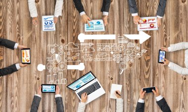 Ellerinde cihazlar bulunan bir grup insan, iletişim ve ağın sembolü olarak birlikte çalışıyor.