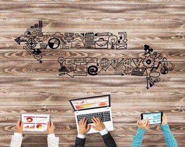 Ellerinde cihazlar bulunan bir grup insan, iletişim ve ağın sembolü olarak birlikte çalışıyor.