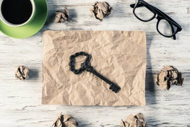 Sayfası, buruşuk Kağıt topları ve ahşap masanın üzerine yerleştirilen kahve buruşuk parçasına üstten görünüm ile anahtar modern yaratıcı çalışma alanı'nın. En iyi fikir bulgusu kavramı.