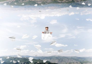 Genç küçük çocuk gözleri koruma kapalı ve seyir bulut uçan kağıt uçaklar arasında ve doğa dünyalar arasında üzerinde meditasyon sırasında konsantre.