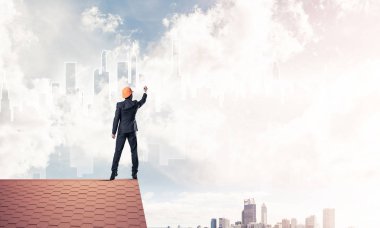 Mühendis, evinin çatısına geri döndü ve şehri çiziyor. Karışık ortam