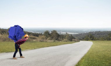 Sırtında kağıt top taşıyan inşaatçı.