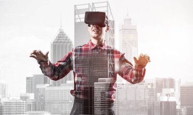 Sanal gerçeklik kulaklığı olan genç bir adam ya da şehrin arka planında 3 boyutlu gözlüklü.