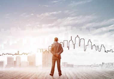 İşadamı arkasını dönüp modern iş merkezinin siluetine bakıyor.