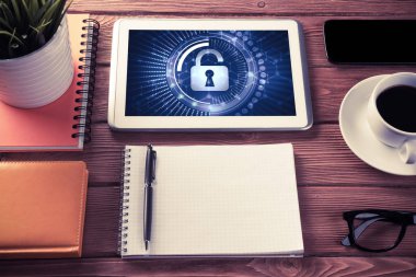 Ofis eşyalarıyla iş yeri ve ekranda asma kilit simgeleri olan tablet