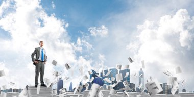 Kendine güvenen işadamı belgeleri kağıtları Clear sky ile arka plan üzerinde uçan arasında yığını üzerinde takım elbise ayakta. Karışık teknik.