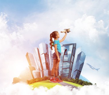 Şehrin yüzen adasında eski model uçaklarla oynayan tatlı bir kız.