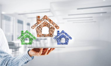 İşadamlarının elinde tablet tablet ve bağlı viteslerden oluşan tabela var. Karışık ortam