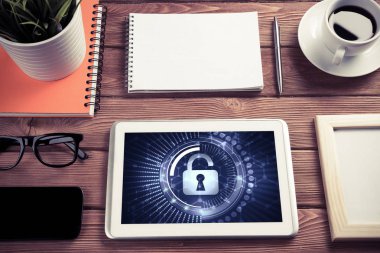 Ofis eşyalarıyla iş yeri ve ekranda asma kilit simgeleri olan tablet