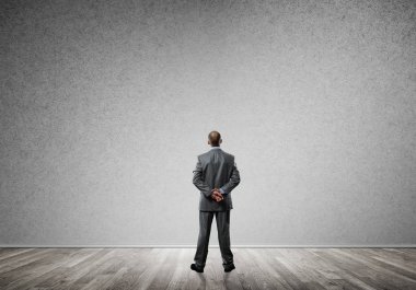 Boş beton odada kendine güvenen zarif iş adamının arka planı