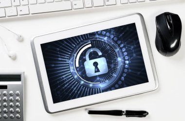 Ofis eşyalarıyla iş yeri ve ekranda asma kilit simgesi olan tablet