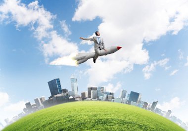 Cityscape ve mavi gökyüzü arka plan üzerinde ile roket üzerinde uçan takım elbiseli genç işadamı kavramsal görüntü.