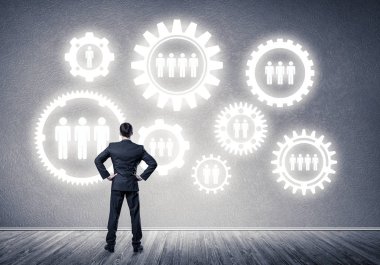 İş adamının çizilmiş dişli mekanizmasıyla duvara baktığı arka plan