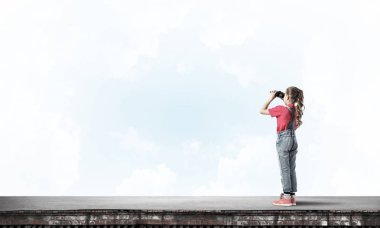 Dürbünle bakan, okul çağındaki sevimli kız çatıyı inşa ediyor.