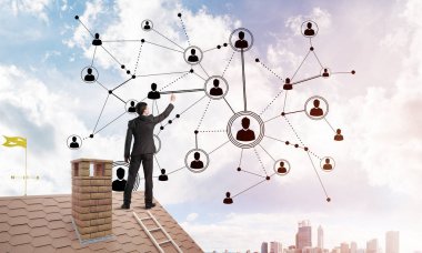 Delikanlı çatıda dikiliyor ve bağlantı hatları çiziyor. Karışık ortam