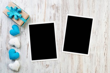 Boş anında fotoğraf ve ahşap masa arka plan üzerinde kırmızı kalpler