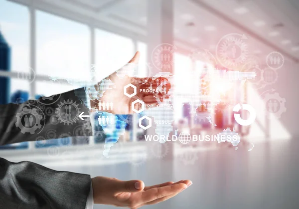 Business woman in suit with media interface and interactive world map in her hands. Sunlight and office view on background. Mixed media.