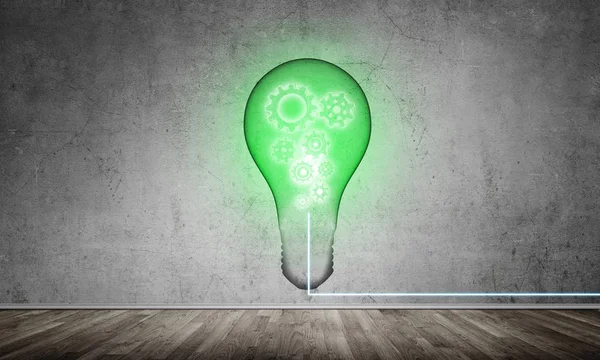 Green glass lightbulb with multiple gears inside placed in empty room with grey wall on background. 3D rendering.