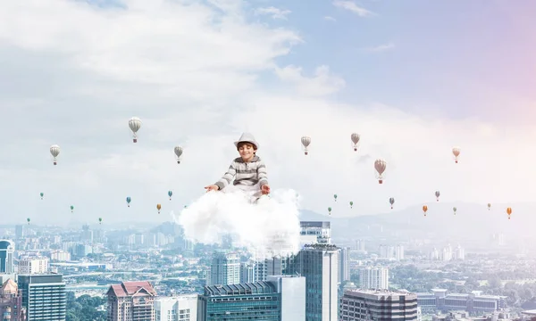 若い男の子の目を維持が閉じられ 都市景観ビューと空気にクラウドに瞑想と背景に気球を飛行しながら集中して見て — ストック写真