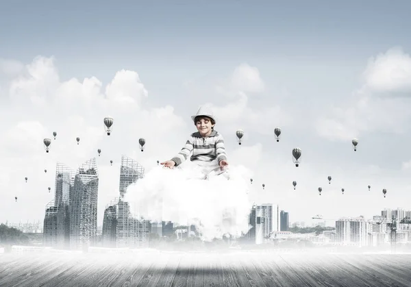 若い男の子の目を維持が閉じられ 都市の景観を望む雲に瞑想と背景に気球を飛行しながら集中して見て — ストック写真
