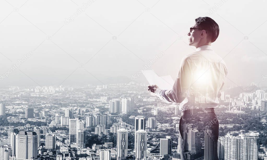 Double exposure of elegant businessman with papers in hands looking away