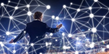 İşadamı gece cityscape sosyal bağlantı medya kavramı ile çalışma karşı arkadan görünüm