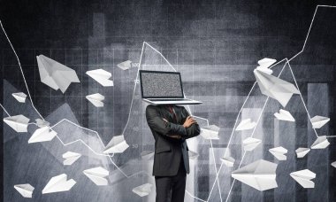 Uçan kağıt uçaklar ve analitik grafikler duvar arka plan üzerinde çizilmiş karşı dururken iş dizüstü bilgisayar kafasına silah tutmak yerine ile takım elbiseli adamı geçti.