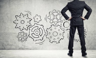 İş adamının çizilmiş dişli mekanizmasıyla duvara baktığı arka plan