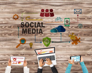 Ellerinde cihazlar bulunan üç kişilik bir grup iletişim ve ağ oluşturma sembolü olarak birlikte çalışıyor.