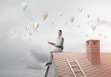 Elinde kırmızı kitap ile ev rahat oturan genç adam