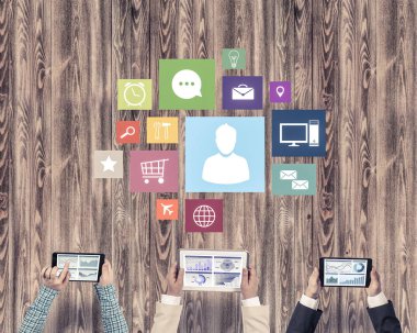 Ellerinde cihazlar bulunan üç kişilik bir grup iletişim ve ağ oluşturma sembolü olarak birlikte çalışıyor.