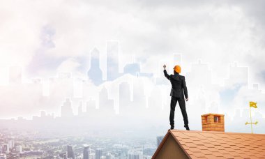 Mühendis, evinin çatısına geri döndü ve şehri çiziyor. Karışık ortam