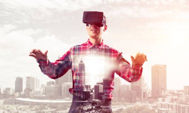 Sanal gerçeklik kulaklığı olan genç bir adam ya da şehrin arka planında 3 boyutlu gözlüklü.
